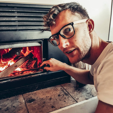 Bluelight filter wooden glasses by Vilo Eyewear. Man wearing bluelight glasses besides a fire